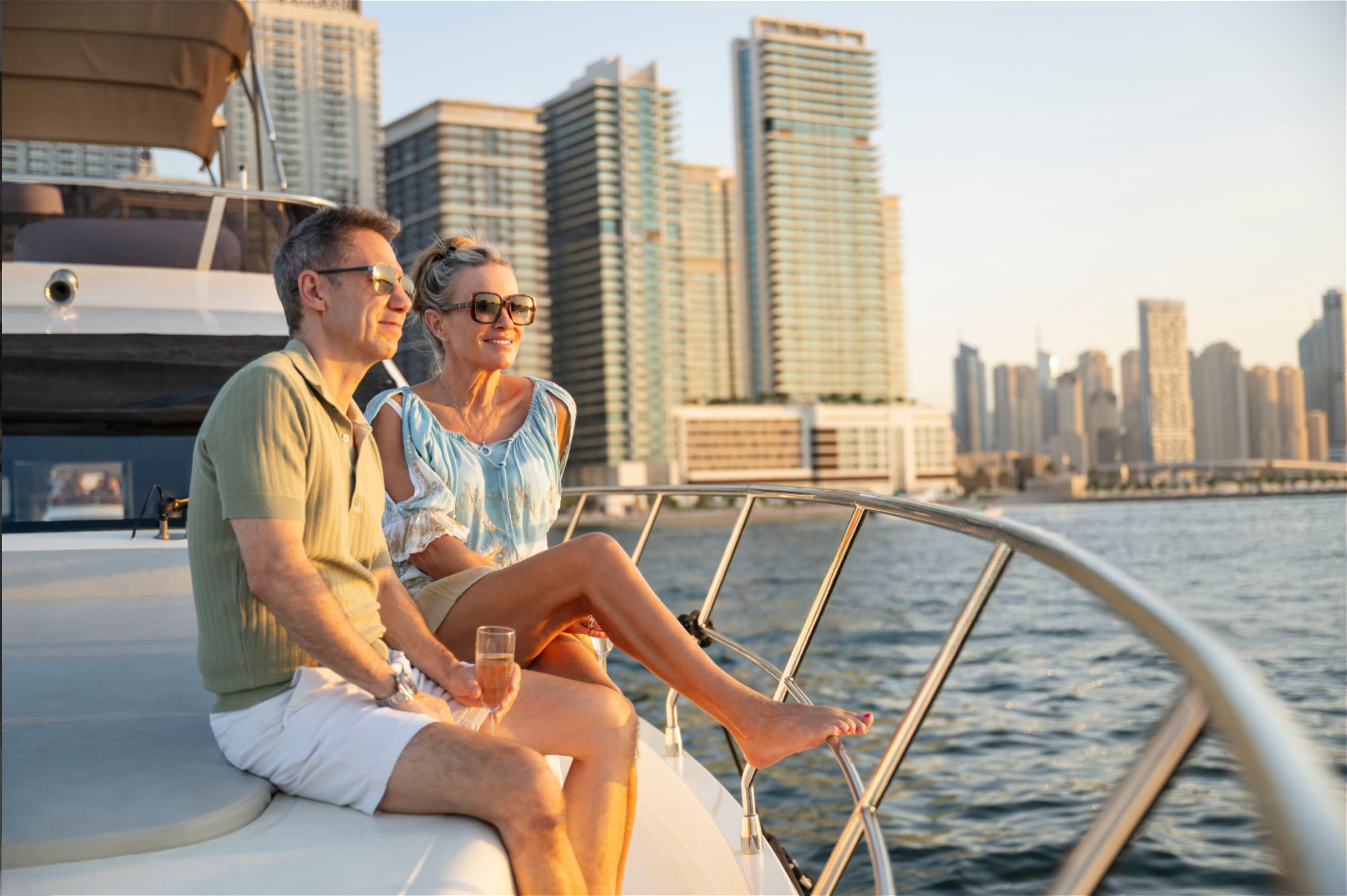 Couple on yacht, enjoying sunny day, with city skyline in the background