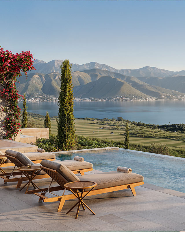 Luxury villa pool area with sunbeds and umbrellas