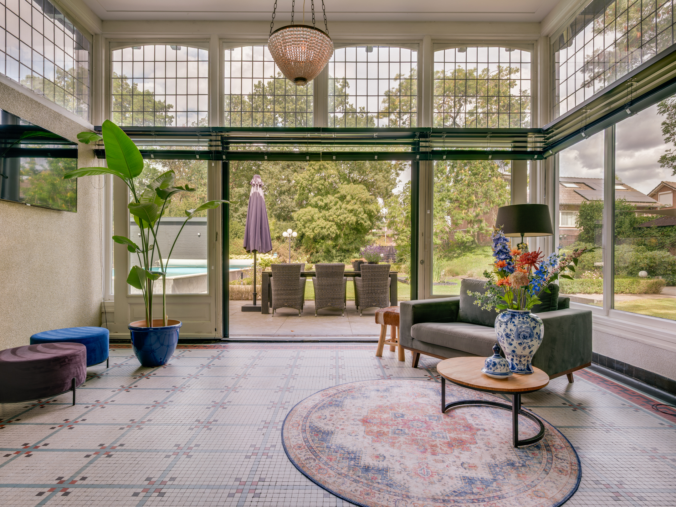 A luxurious house room with elegant furniture, large windows, and tasteful decor, showcasing a blend of classic and modern design elements.