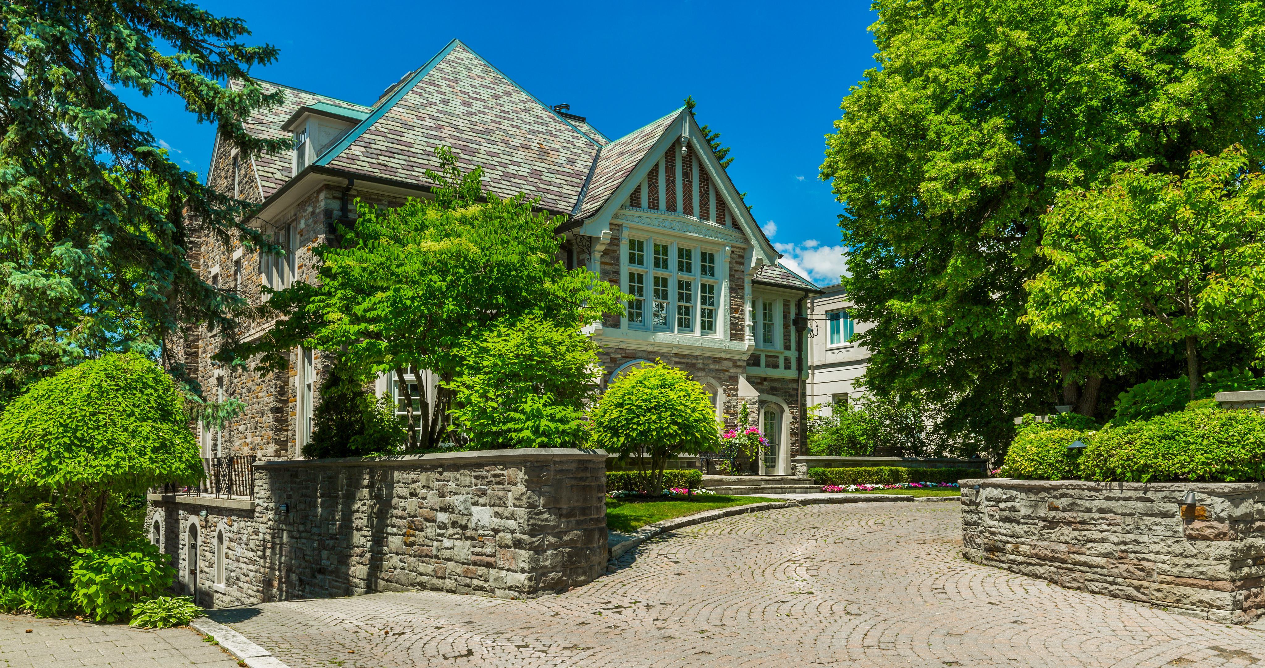 A luxurious house viewed from the outside, with a well-maintained garden and a driveway.